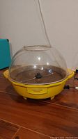 Side view of yellow Toastess Cinema Popper with clear dome lid and front label visible.