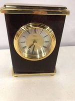 Front view of a Birks quartz clock with gold-tone bezel and Roman numeral clock face.