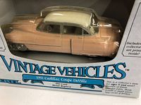 Front view of the die-cast model car inside original box showing peach and white 1952 Cadillac Coupe DeVille with box branding and scale information.