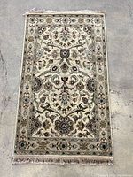 Full view of rug laid flat on concrete floor showing overall pattern