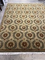 Full view of rug laid flat showing pattern and fringed ends