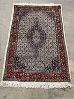 Full view of rug laid flat showing overall design, border, and fringes