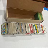 Photo showing a large stack of assorted New York Yankees baseball cards laid out next to an open cardboard box for storage.