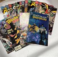 Photo showing a collection of DC comic books spread out, featuring Batman, Robin, Joker, Harley Quinn, and Batman Night Gallery issues.