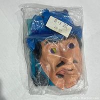 Front view of Big Boy character mask with cracks inside sealed plastic bag