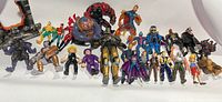 Wide shot showing all 25 varied action figures including Batman, Gargoyles, Dick Tracy characters and others.