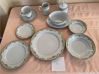Top front view of the china pieces arranged on a peach tablecloth.