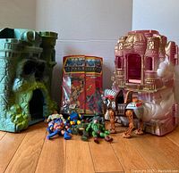 Front view showing green Castle Grayskull, pink Princess of Power Castle, figures, horse and card pack