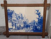 Front view of the antique Dutch Delft tile wall art framed in wood, showing the full street scene with people and buildings in blue and white.