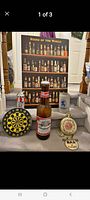 Photo of various bar items including large Budweiser bottle, dart board, beer stein, bar clock, and a 'Beers of the World' display board in background.