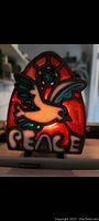 Close-up front view of the vintage metal and glass candle holder featuring a white dove flying over the word 'PEACE' with a red and orange stained glass background and blue star.
