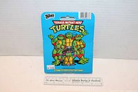 Image of sealed 1990 Topps Teenage Mutant Ninja Turtles 66 card collector set showing front of packaging featuring illustrated turtles on blue background.