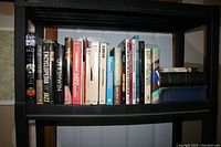 Photo showing a full view of hardcover jazz books on a black shelf including titles and condition.