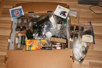 Overview of large lot with multiple vacuum tubes, some boxed and some loose in plastic bags, plus various electronic components.