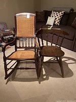 Front and side view of the wooden rocking chair with cane seat and back alongside a wooden dining/side chair, both showing wear.