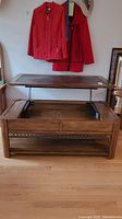 Full view of the wooden coffee table with top raised showing the tile inset and storage compartment beneath.