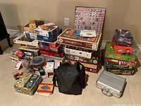 Overall view of stacked puzzles, board games, card decks, poker chips and other game materials on floor.