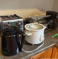 Wide view showing all appliances including toaster, teapot, slow cooker, coffee maker, and griddle.