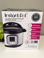 Front view of boxed Instant Pot 7-in-1 multi-use programmable pressure cooker showing model and key features like cooking faster and smart controls.