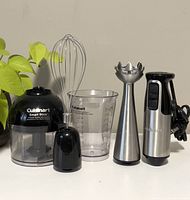 All components of the Cuisinart Smart Stick set displayed: chopper with lid, whisk, stainless steel blending shaft, motor unit, and 2-cup container.