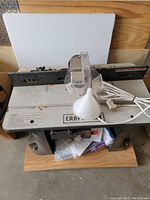 Craftsman table router showing working surface, fence, power cord, and dust collection funnel