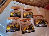 Five Menards limited edition Gold Line tractor loader toys in original packaging on a table.