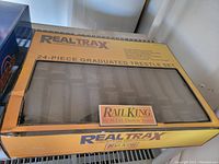Top view of original yellow box labeled RealTrax 24-piece graduated trestle set by MTH Electric Trains, Rail King branding visible.