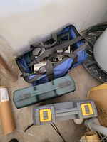 Blue duffle bag containing handheld routers with visible labels and handles