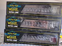 Photo of three boxed Weaver Ultra Line model train cars, showing front of packaging and train car details