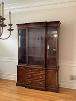 Front view of Hickory china cabinet showing closed glass doors, three center drawers, and two side cabinets.