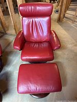 Front view of red leather recliner and ottoman showing overall styling and condition