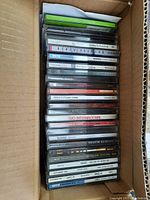 Box of CDs viewed from the top showing spines with various titles and artists.