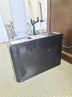 Side view of black Dell Vostro desktop computer tower showing worn surface and ventilation fan area.