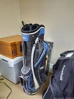 Side view of black, blue and gray iTech RC golf bag showing several zippered pockets and carrying handles