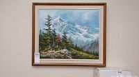 Framed landscape painting showing a mountain with pine trees in foreground, stained mat visible.