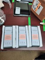 Four sealed packs of white Threshold ultra soft cotton pillowcases arranged on a table with an iPad and boxes nearby.