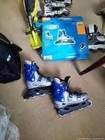 Men's inline skates in silver and blue next to their original blue ProStar box, size 11 labeled on box.