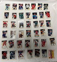 Top side view showing 42 hockey cards in rows on white cloth, featuring pictured NHL players