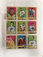 Top side view of nine vintage 1972-73 O-Pee-Chee hockey cards featuring NHL players, each in clear protective sleeves for preservation.