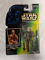 Front view of sealed Star Wars Dengar figure in Kenner packaging showing detailed figure and blaster rifle accessory.
