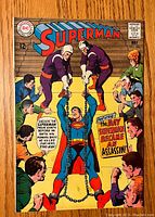 Front cover of Superman comic book issue #206 showing Superman chained and men threatening him.