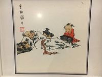 Watercolor painting depicting two traditional figures, framed and behind glass, showing signed stamp and title.