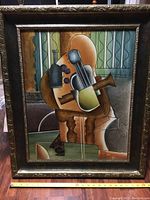 Full front view of the framed artwork depicting an abstract violin with carved and painted details.