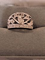 Close-up frontal photo of white gold diamond cluster ring showing intricate openwork design with round diamond and teardrop shapes.