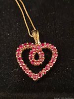 Front view of heart pendant on chain against black background