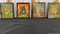 Four vintage wood backed cat prints displayed in a row, showing variety of cats and colors