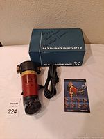 Photo of the pump with original box, power cord and manual laid out.