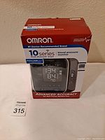 Front view of sealed Omron 10 Series BP786 wireless upper arm blood pressure monitor box, showing branding and product screen with digital reading displayed.