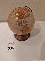 Side view of globe showing Americas on the map and bronze-colored base.