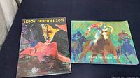 Two LeRoy Neiman art books side by side, 2015 on left vertical, 2014 on right horizontal showing front covers